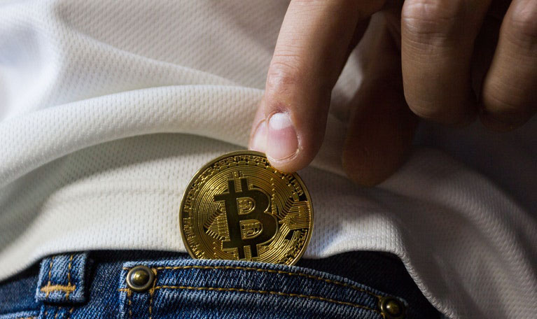 a man putting bitcoin in his back pocket